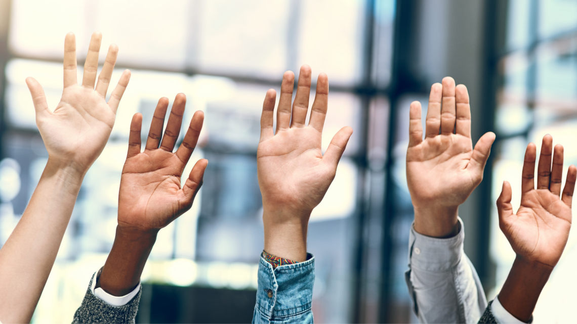 A group of people are raising their hands in the air.