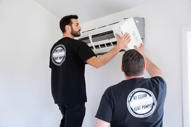 Workers from We Clean Heat Pumps franchise installing equipment.