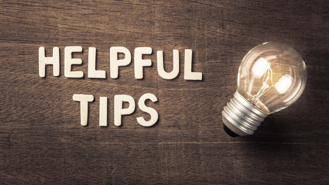 A light bulb is sitting on a wooden table next to the words helpful tips.