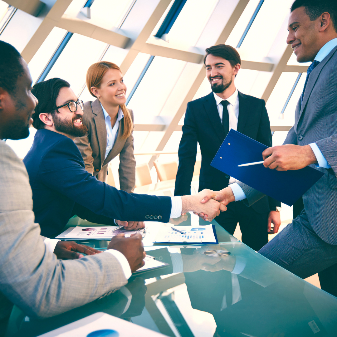 A group of business people shaking hands at a table