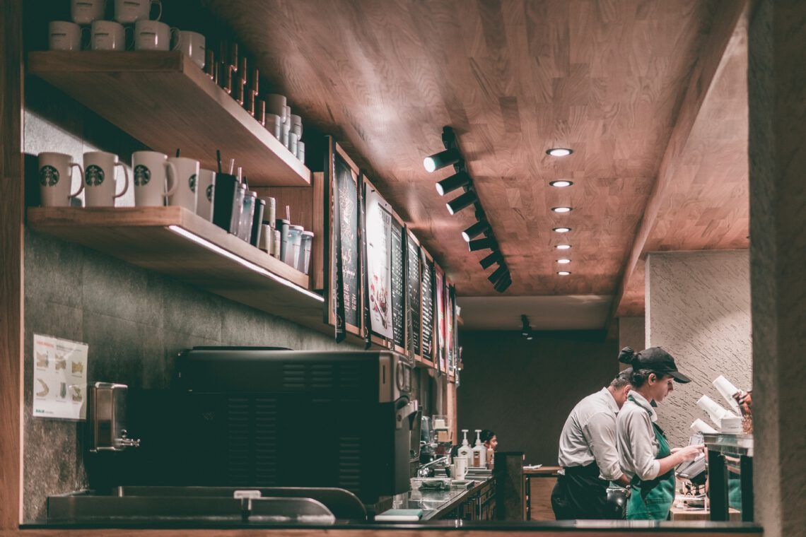 A couple of franchise owners are working in a kitchen in a restaurant.