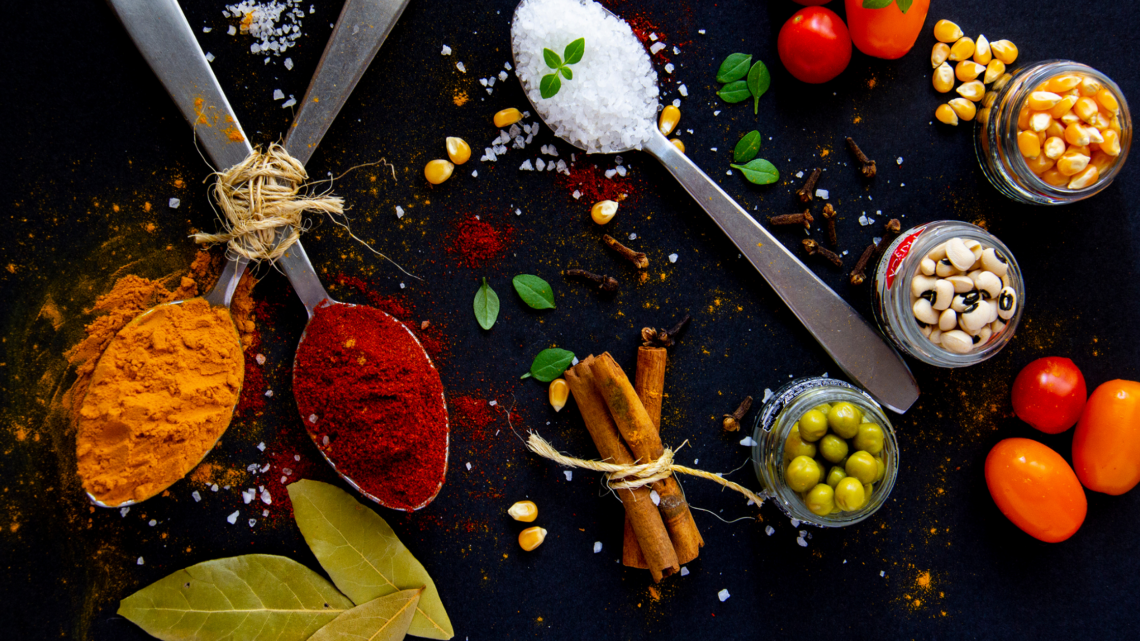 A table topped with spoons filled with different types of spices and vegetables.