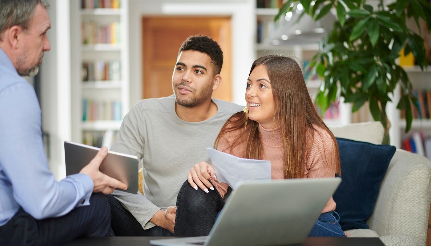 Young couple listening to business advice, representing the key benefits of hiring a franchise consultant before investing.