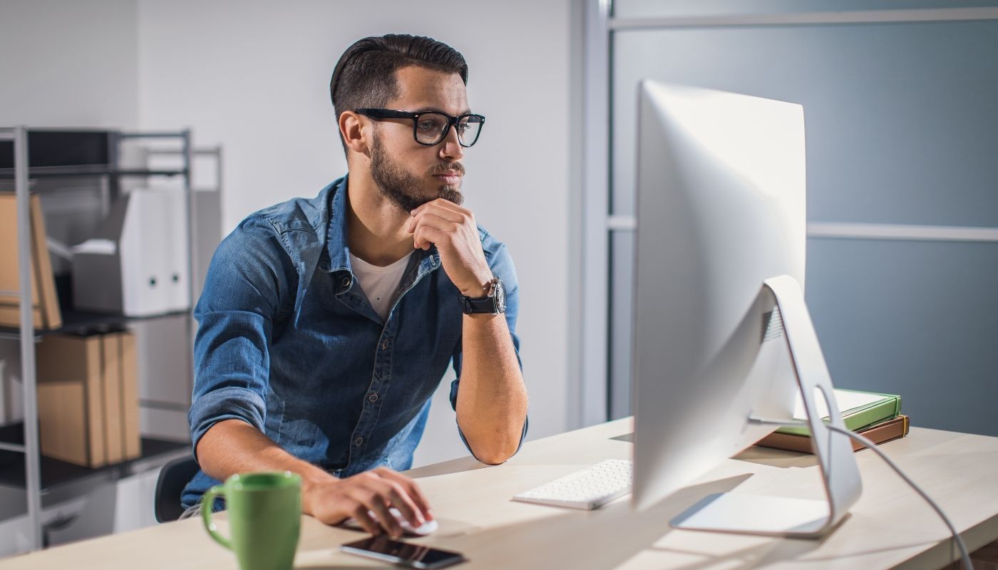 Young businessman using computer, planning a franchise exit strategy
