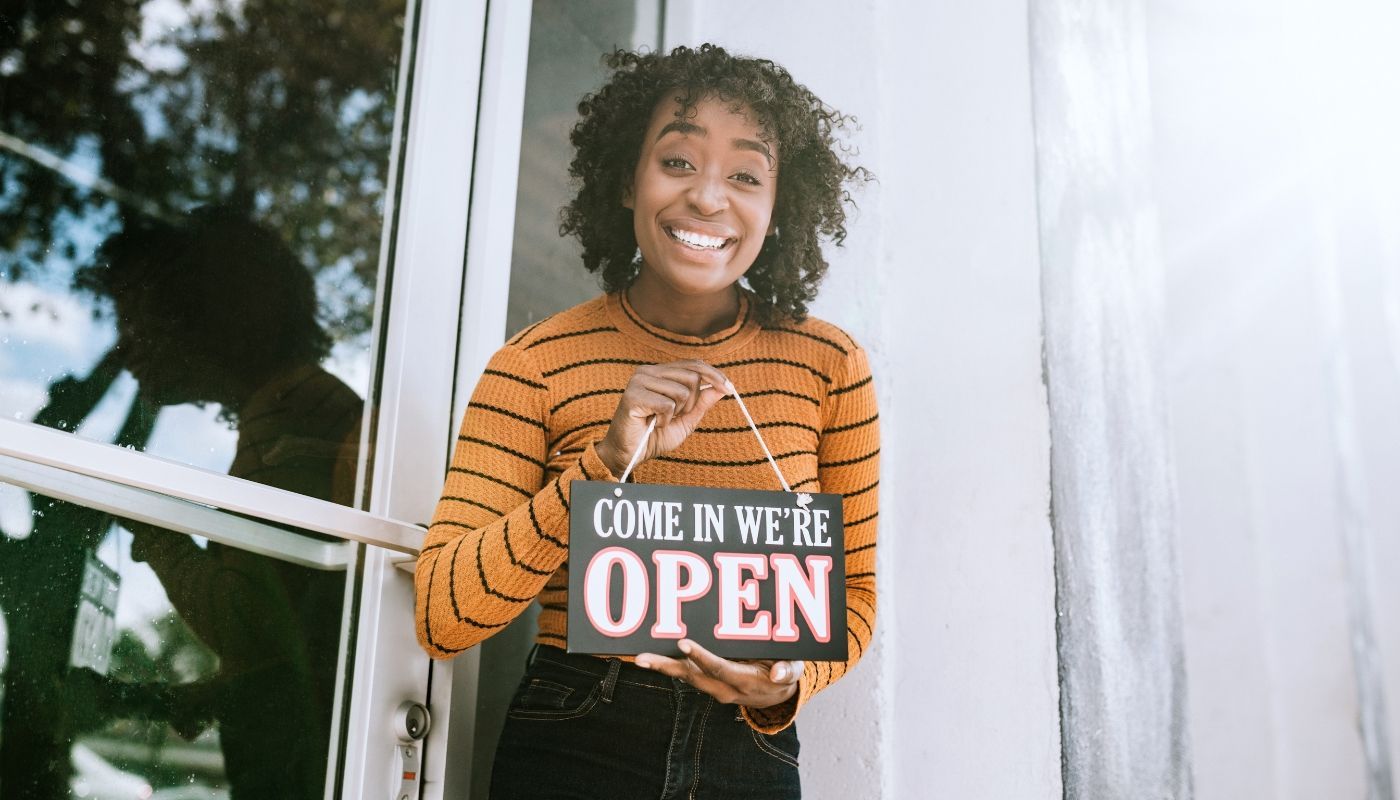 Female business owner holding up a 