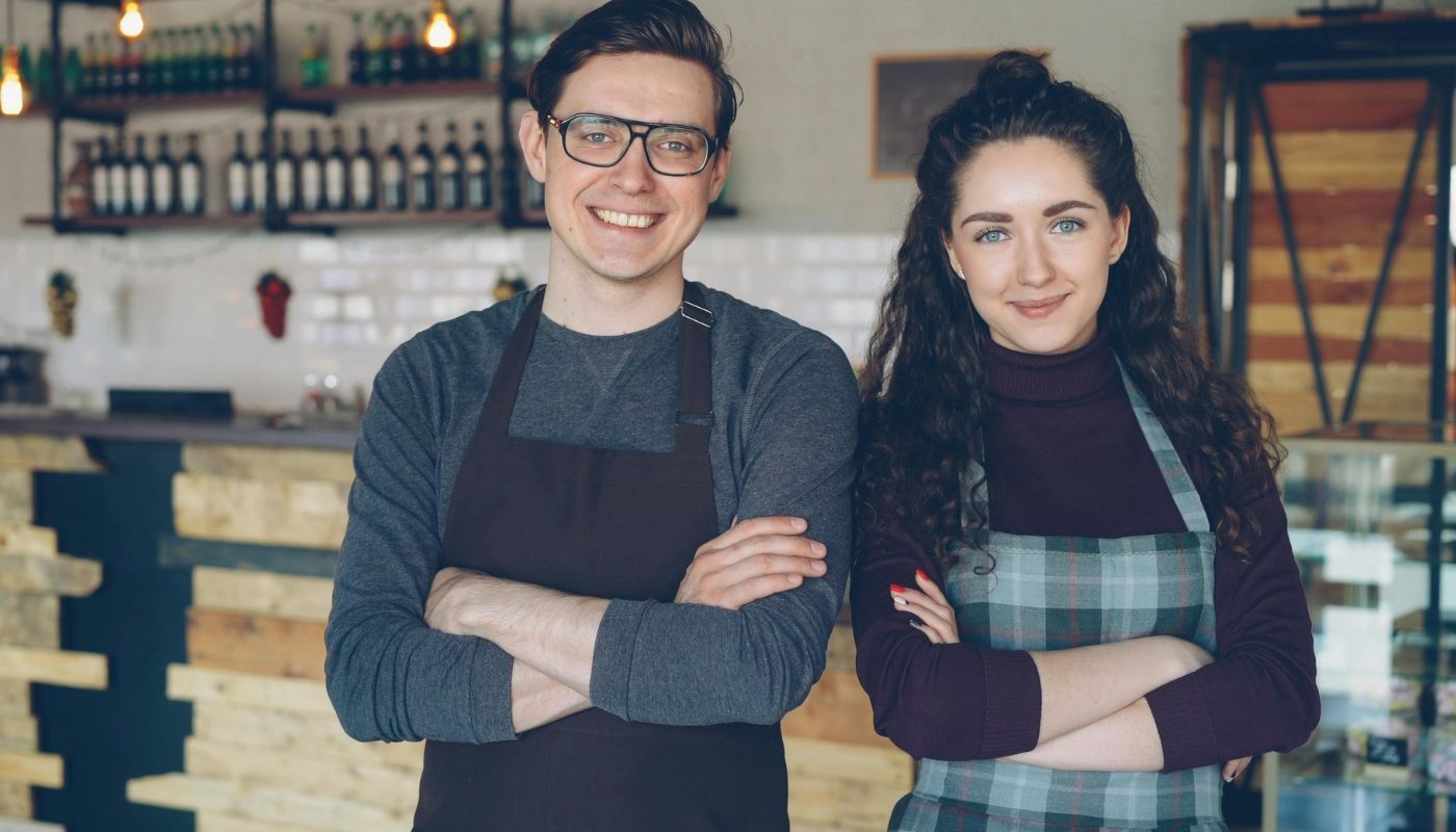Young business owners smiling while building franchise ownership.