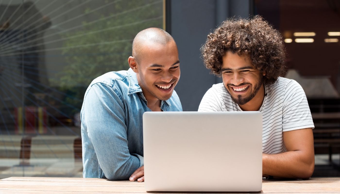 Two men using computer, taking the first steps towards franchise ownership