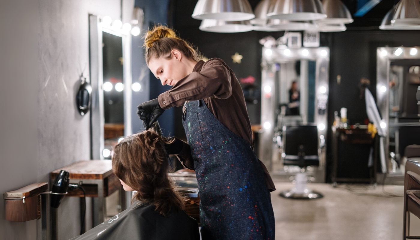 Hairdresser styling hair in a hair salon franchise
