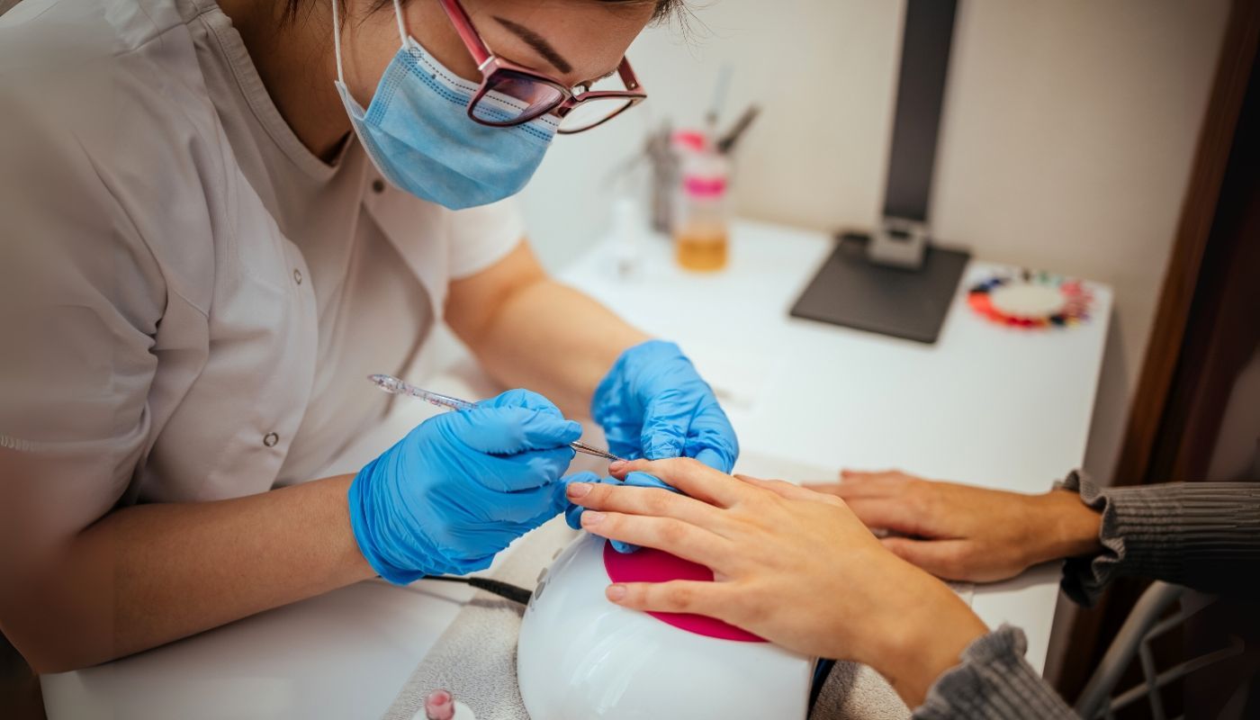 Nail technician working with a client in a nail salon franchise