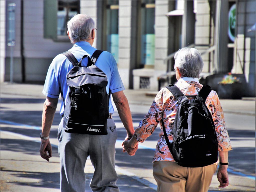A man and a woman are walking down the street holding hands.
