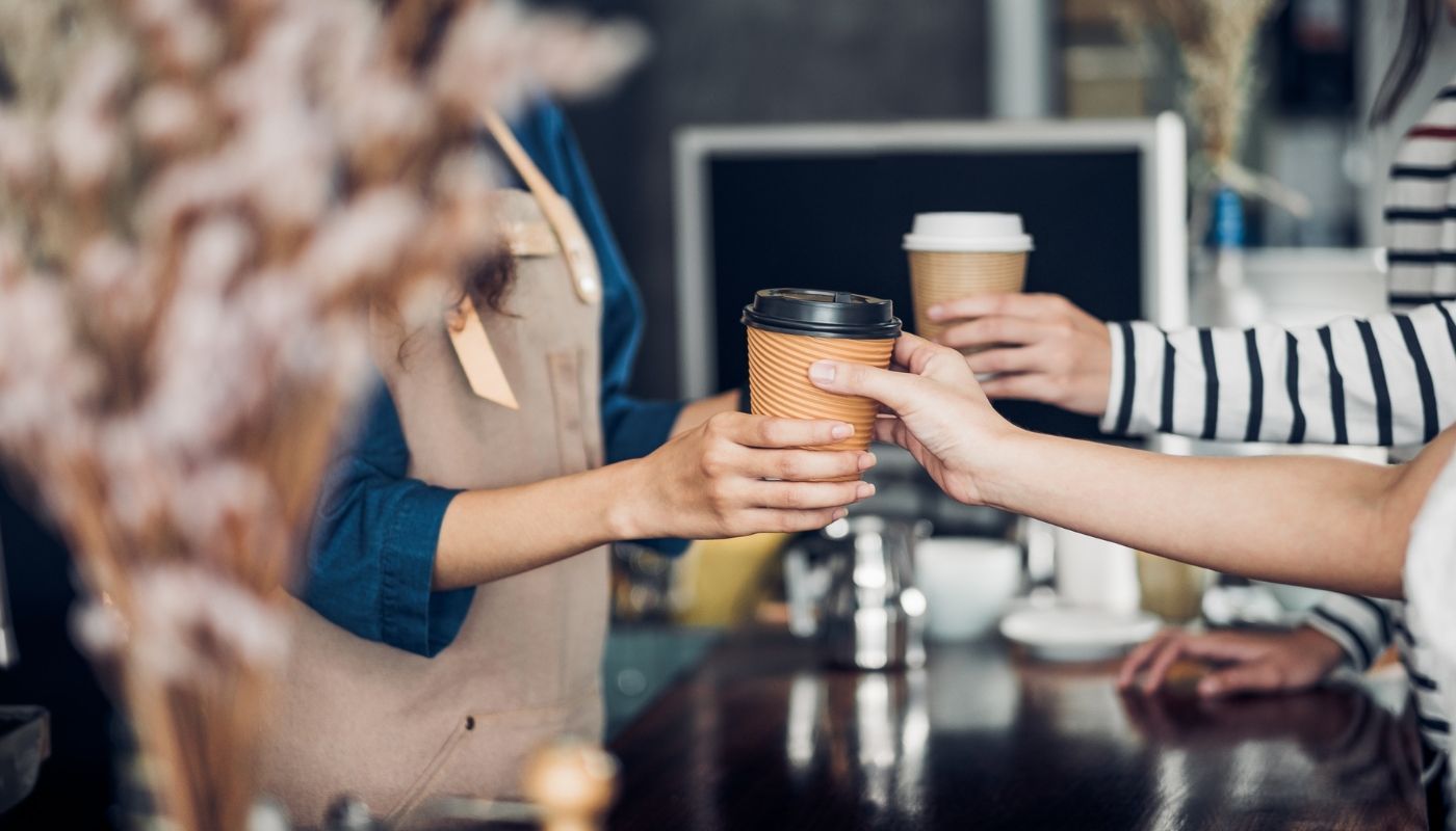 Top franchises, barista in cafe serving coffee to customer