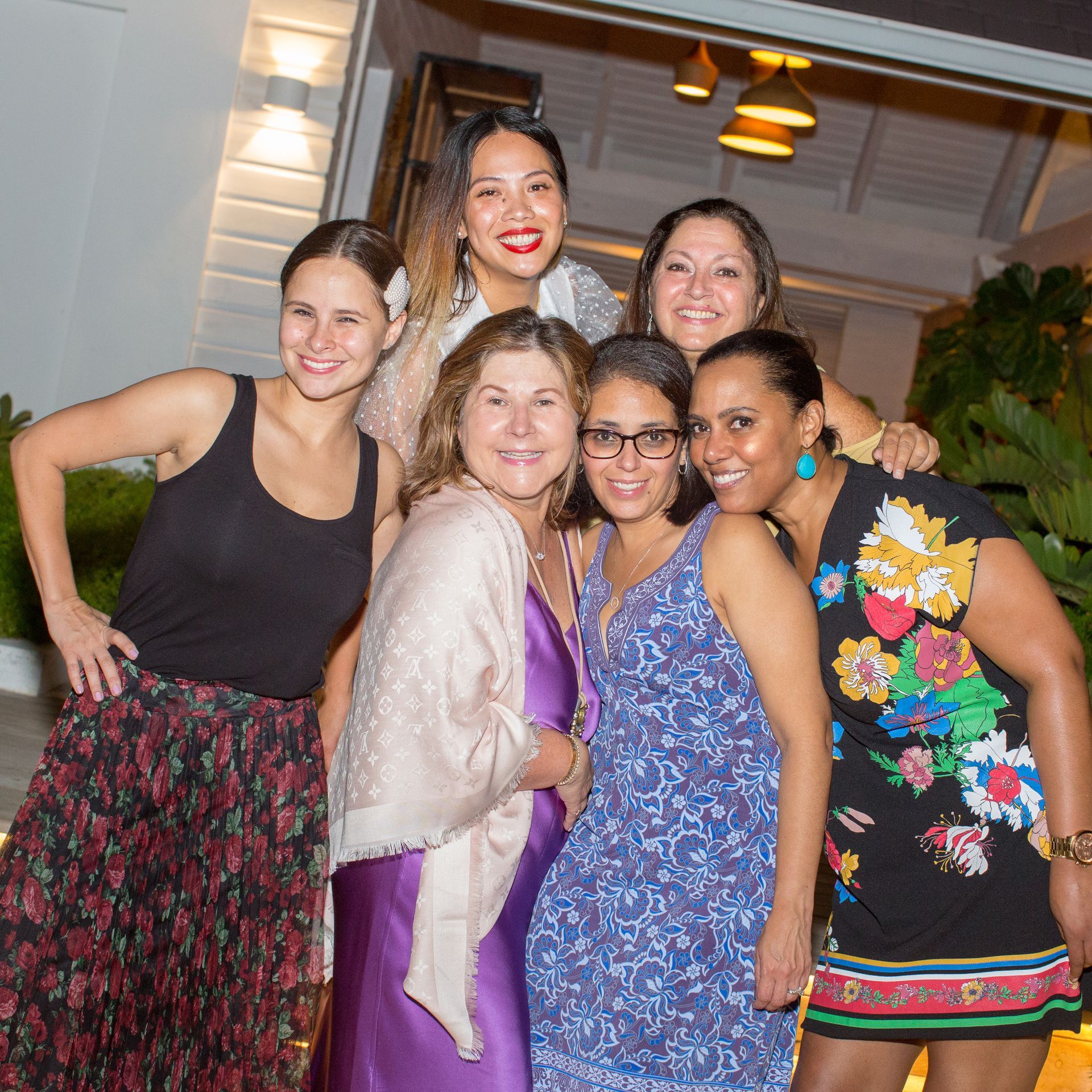 Tropical resort on a white sand beach with a turquoise ocean and lush green mountains.