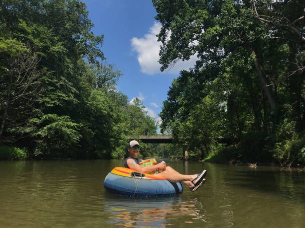 A woman is floating down a river in a tube.