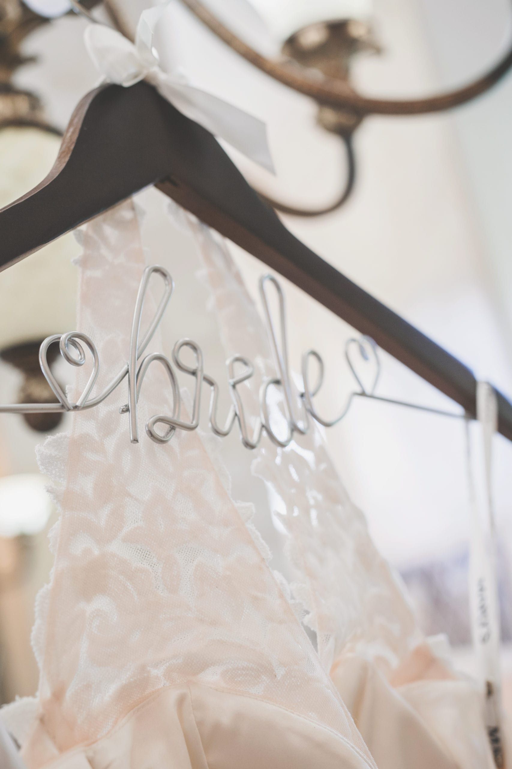 Bride's wedding dress on a dark wooden hanger with 