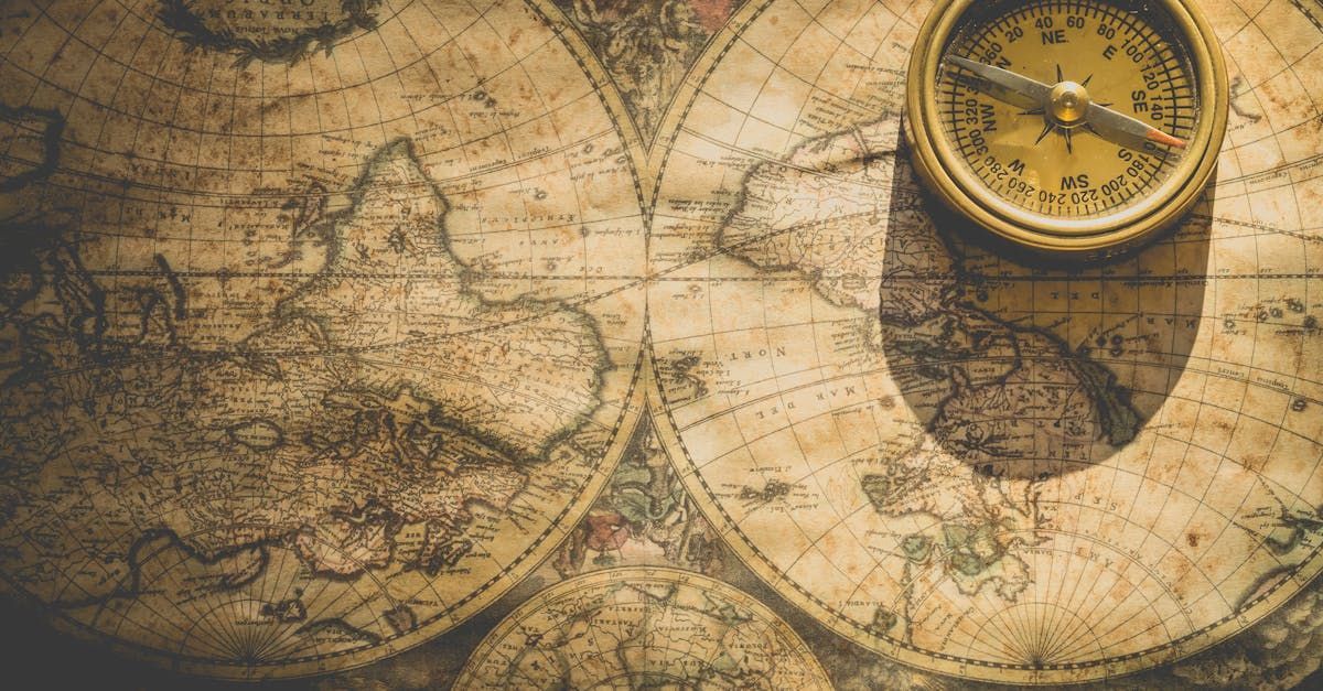 An old compass is sitting on top of an old map.