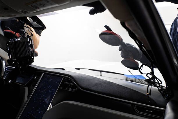 Driver’s view from inside a car, showing dashboard and windshield wipers in rainy conditions