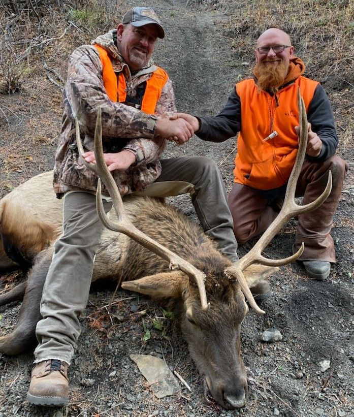 Men holding a big elk.