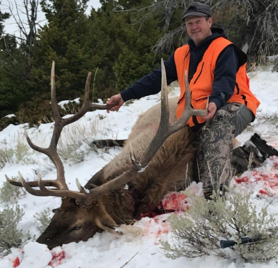 A man holding a big elk.