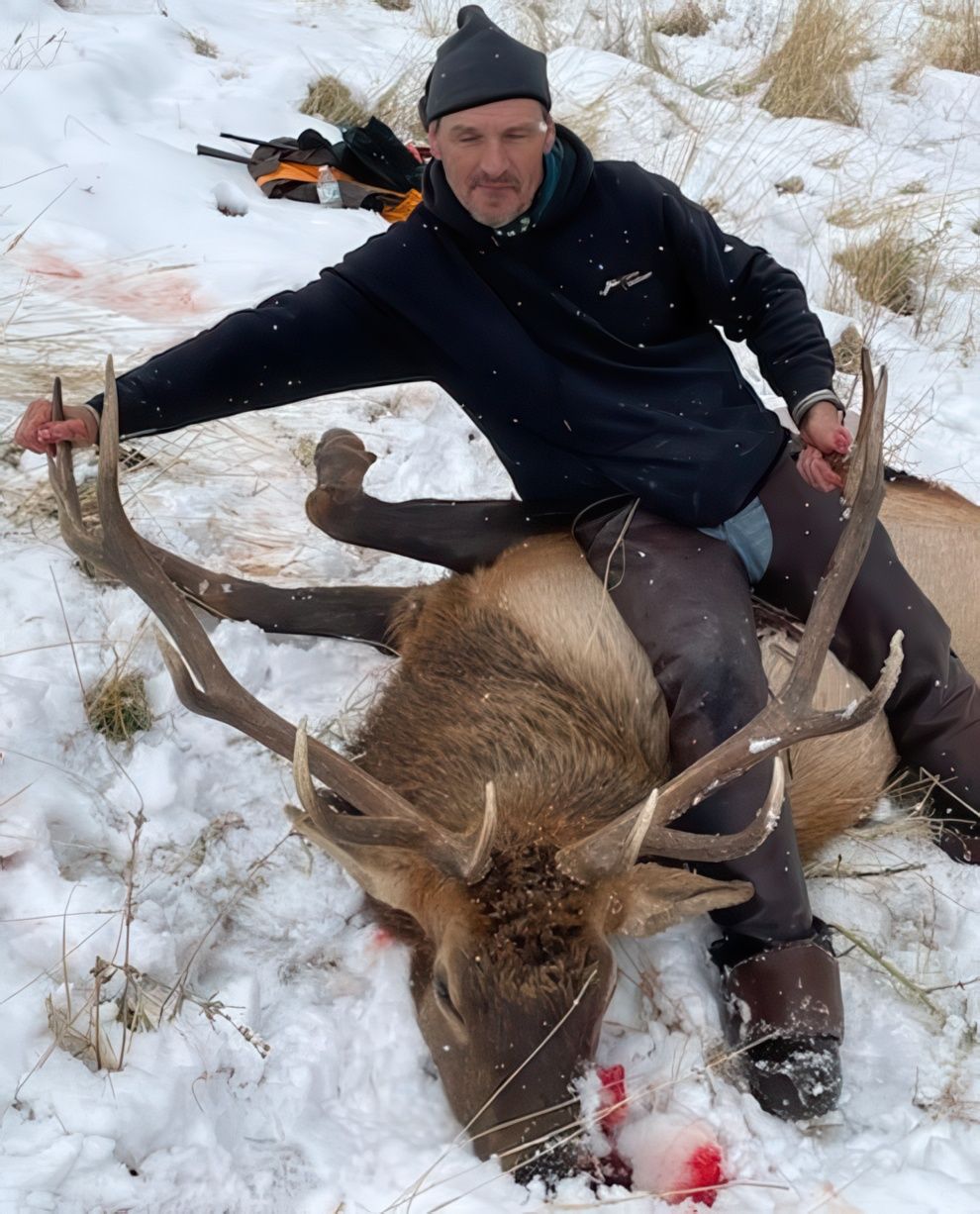 A man holding a big elk.