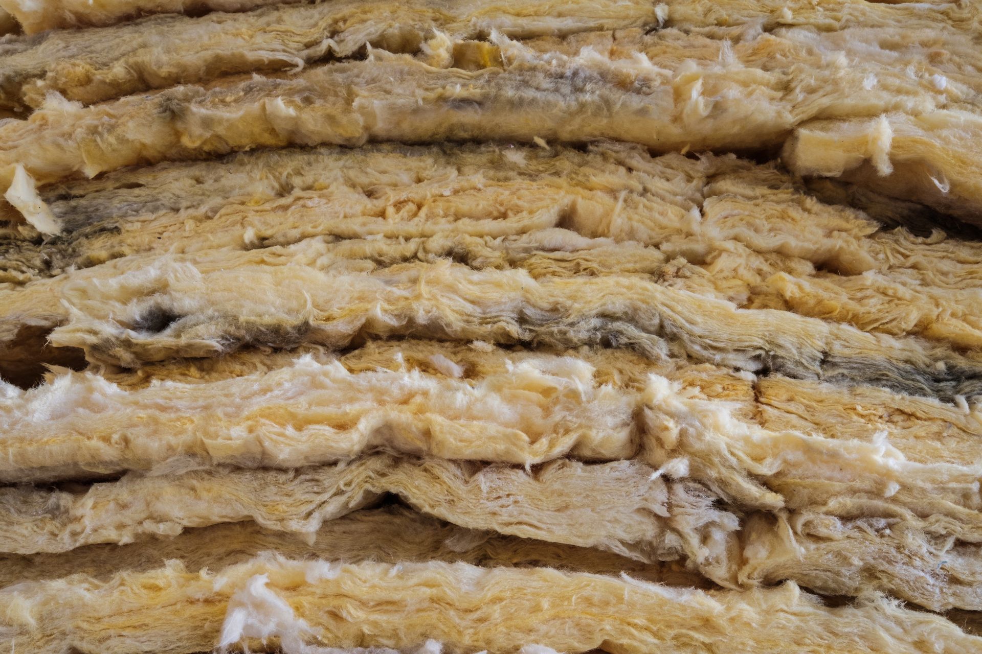 Layers of yellow-white, textured material stacked together, possibly insulation or a similar product.