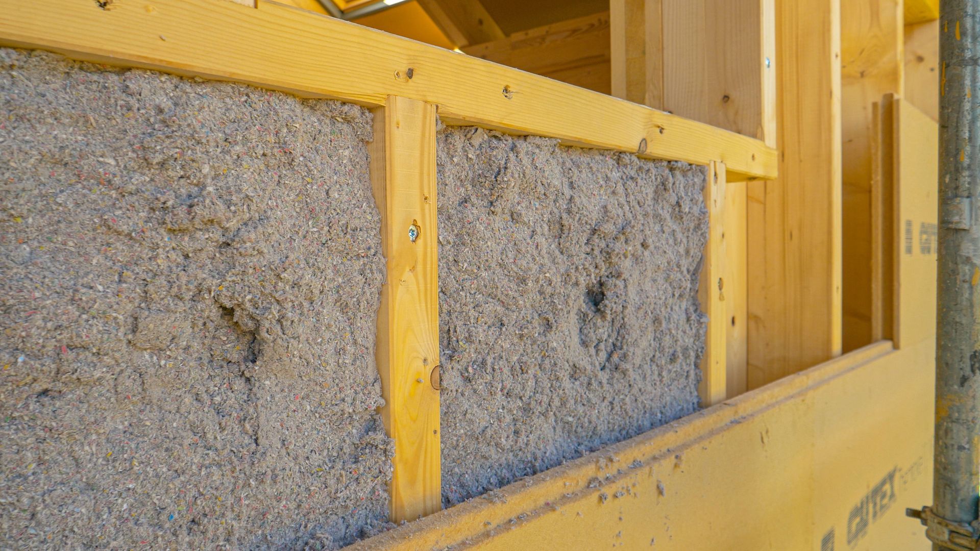 Wooden wall construction with insulation material in the cavity.