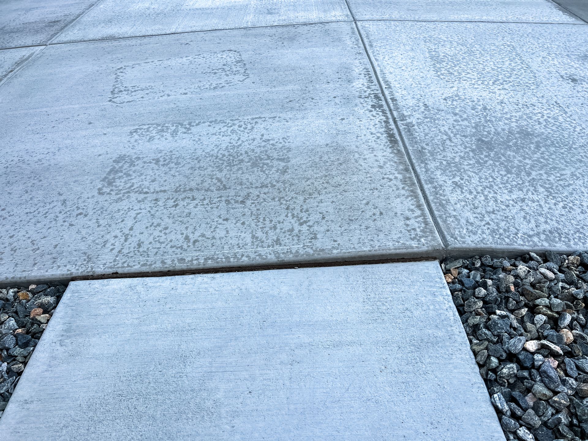 Concrete pavers on a walkway with gravel border.