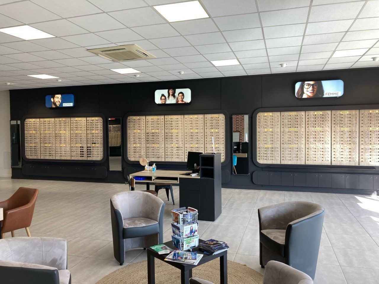 Intérieur d'un magasin d'optique avec des présentoirs de lunettes sur des murs