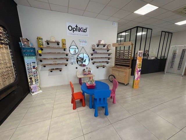 Intérieur d'un magasin d'optique présentant des présentoirs de lunettes pour enfants