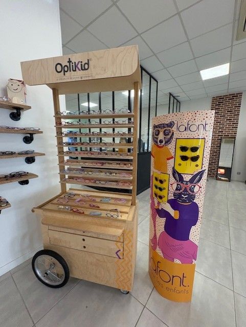 Magasin d'optique avec présentoir à lunettes et présentoir promotionnel coloré. 
