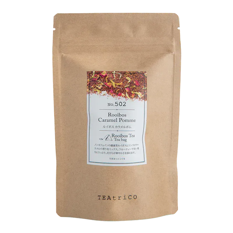 棕色茶包,標籤上寫著“Rooibos Caramel Pomona”,可以看到茶葉,標籤為白色。