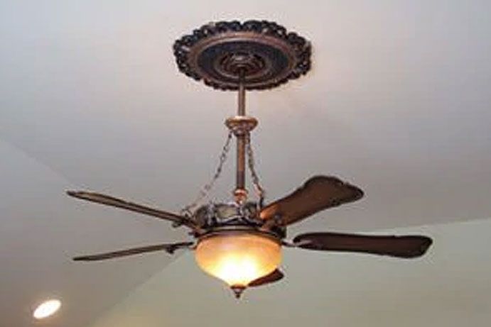 A ceiling fan with a light attached to it is hanging from the ceiling.