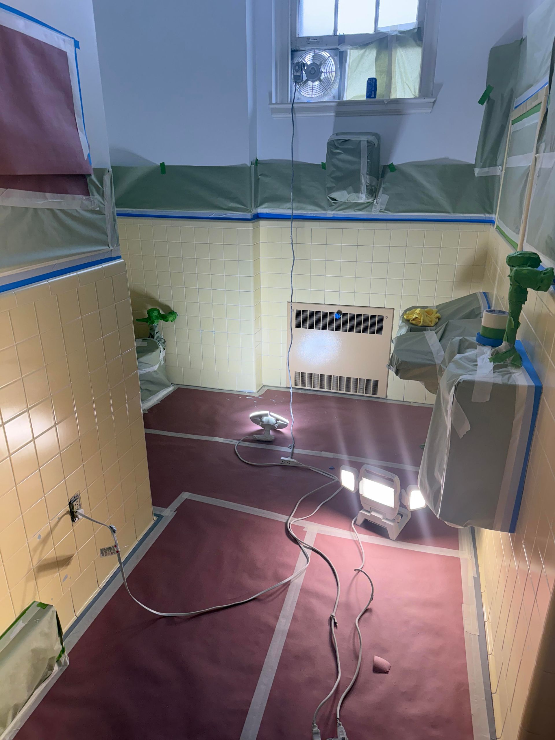 Empty room with taped-off walls, maroon carpet, exposed cords, and a small window above a vent.