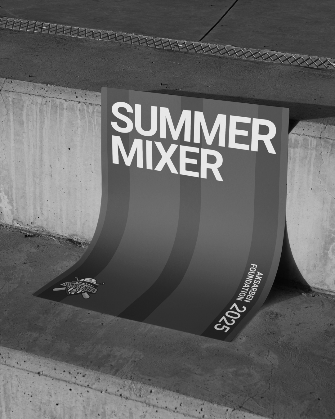 Four smiling people in a kitchen. One holds a tray. Black and white.