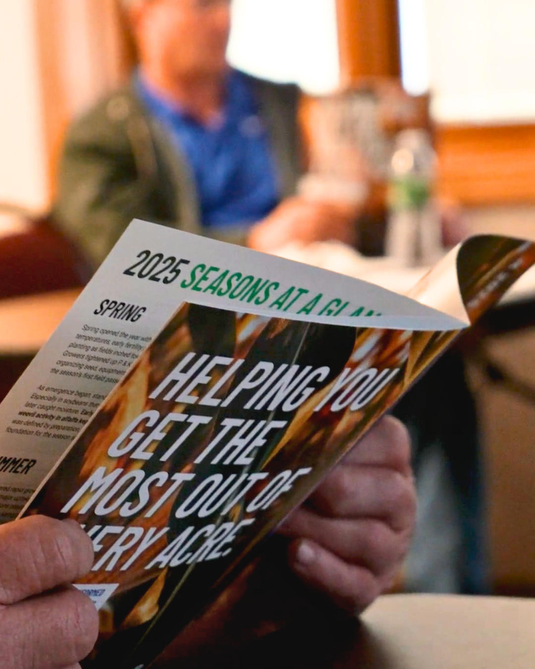 Dark green cylindrical tank with blue logo against a blue sky with clouds.