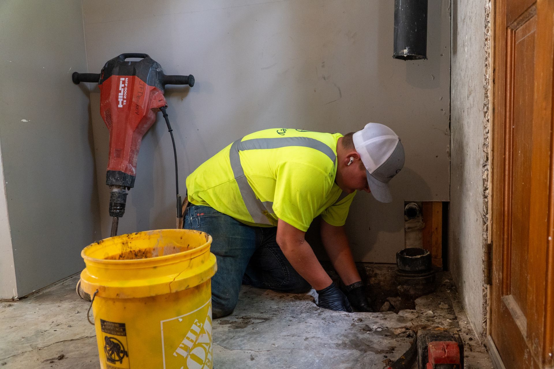 A man is using a camera to take a picture of a manhole cover.
