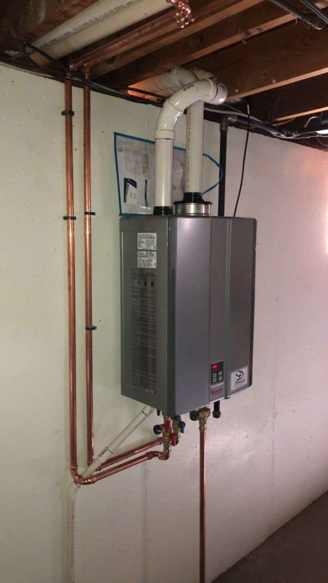 A water heater is mounted to the wall in a basement.
