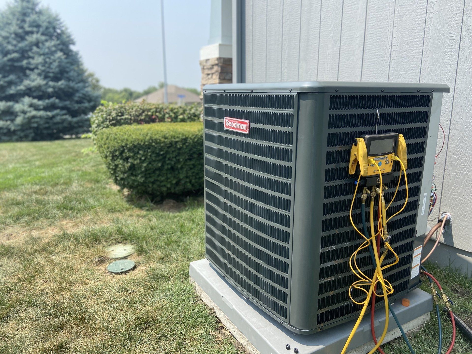 A large air conditioner is sitting on the side of a house.