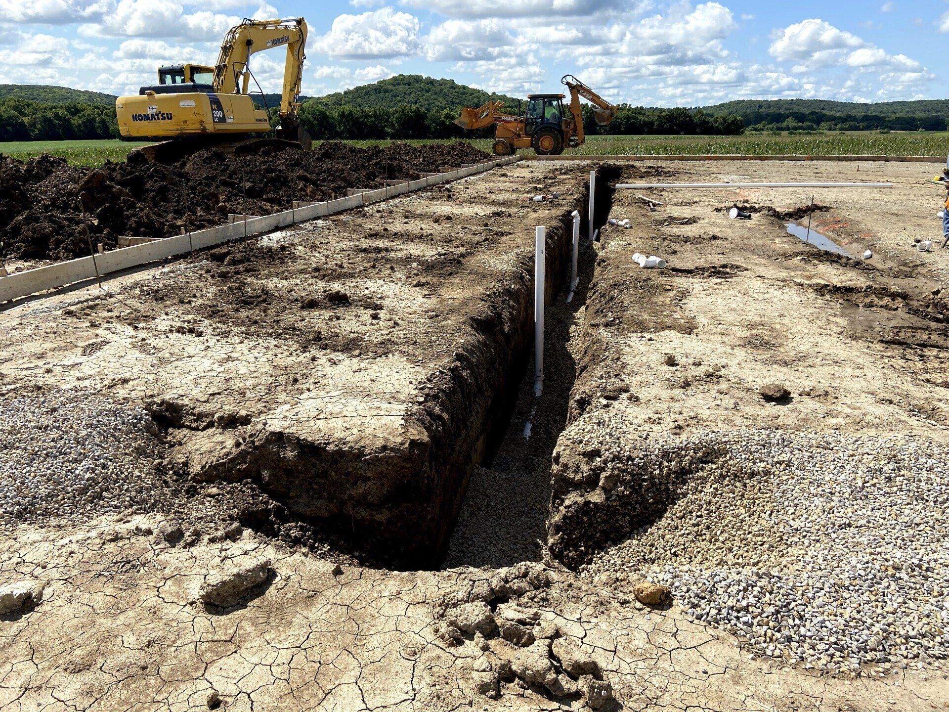 A large yellow excavator is digging a hole in the ground.