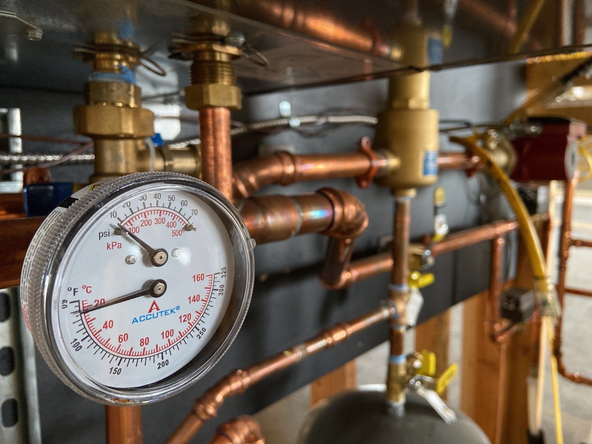A pressure gauge is sitting on top of a copper pipe.