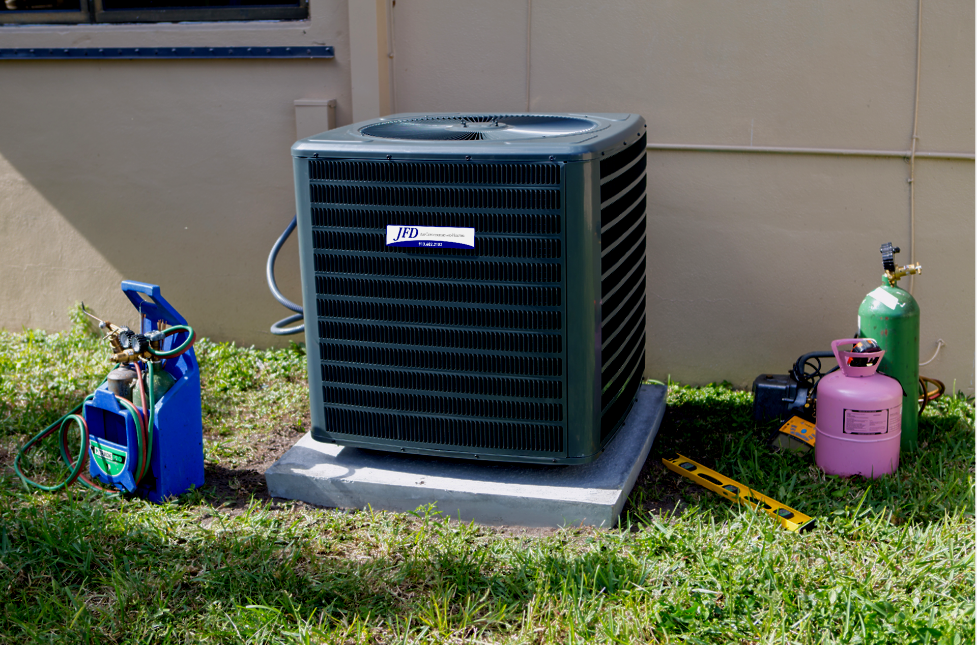 An air conditioner is sitting on top of a concrete block in the grass.