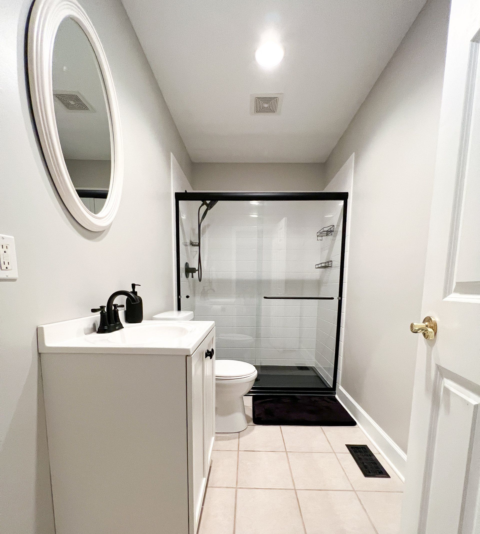 A bathroom with a toilet a sink and a mirror
