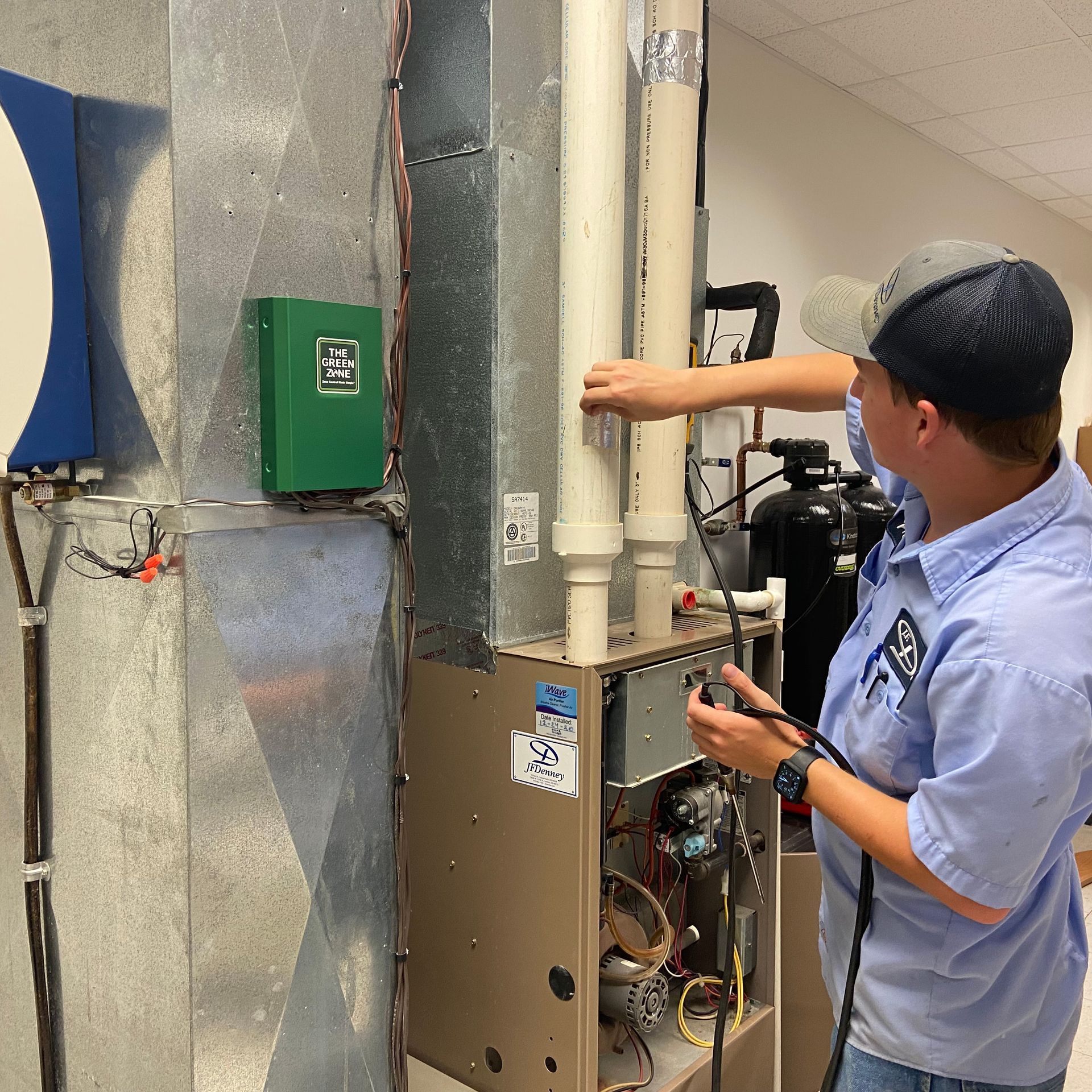 Two men are working on a stainless steel hood