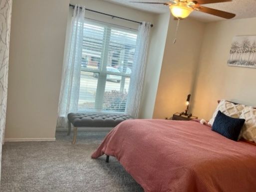 Interior of bedroom with large ceiling fan and window