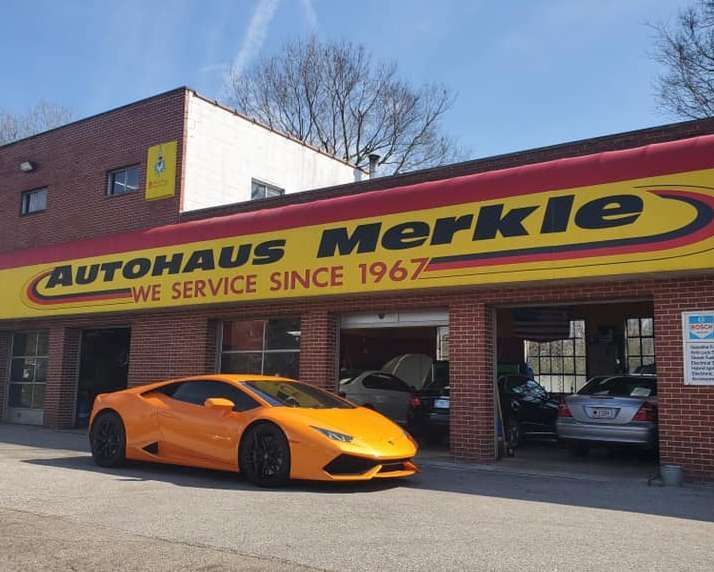 A yellow sports car is parked in front of autohaus merkle