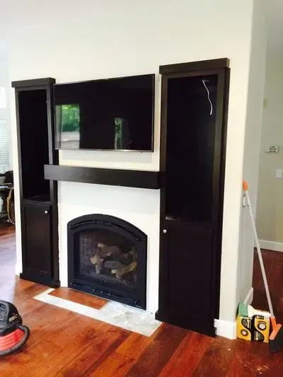 A living room with a fireplace and a flat screen tv