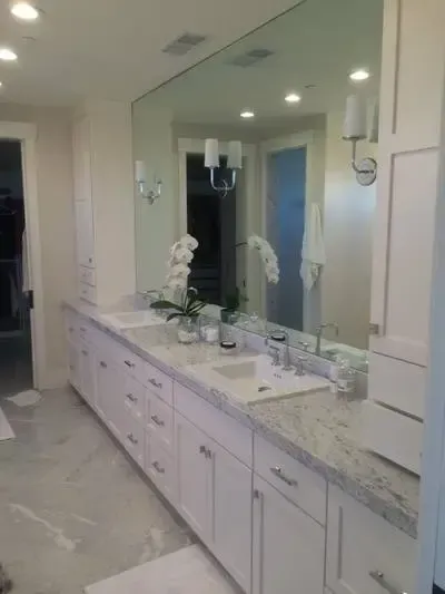 A bathroom with two sinks and a large mirror