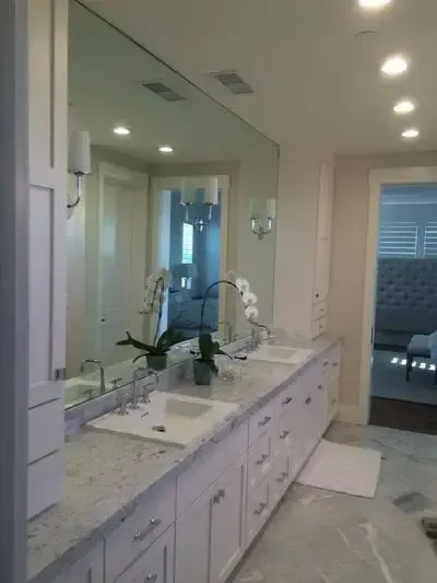 A bathroom with two sinks and a large mirror.