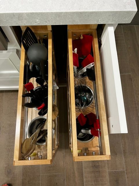 Two drawers in a kitchen filled with pots and pans