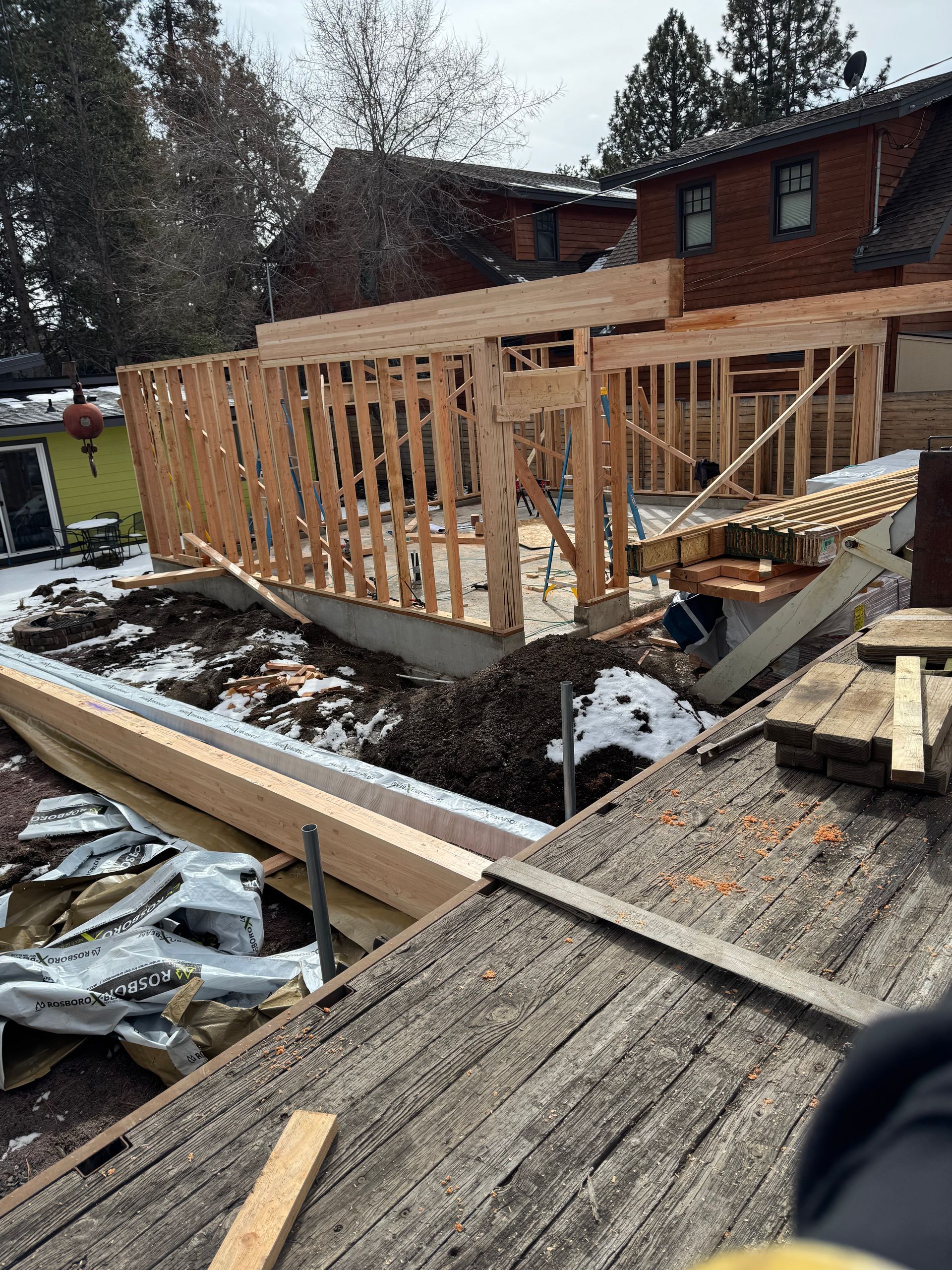 A house is being built with wooden beams and a roof.