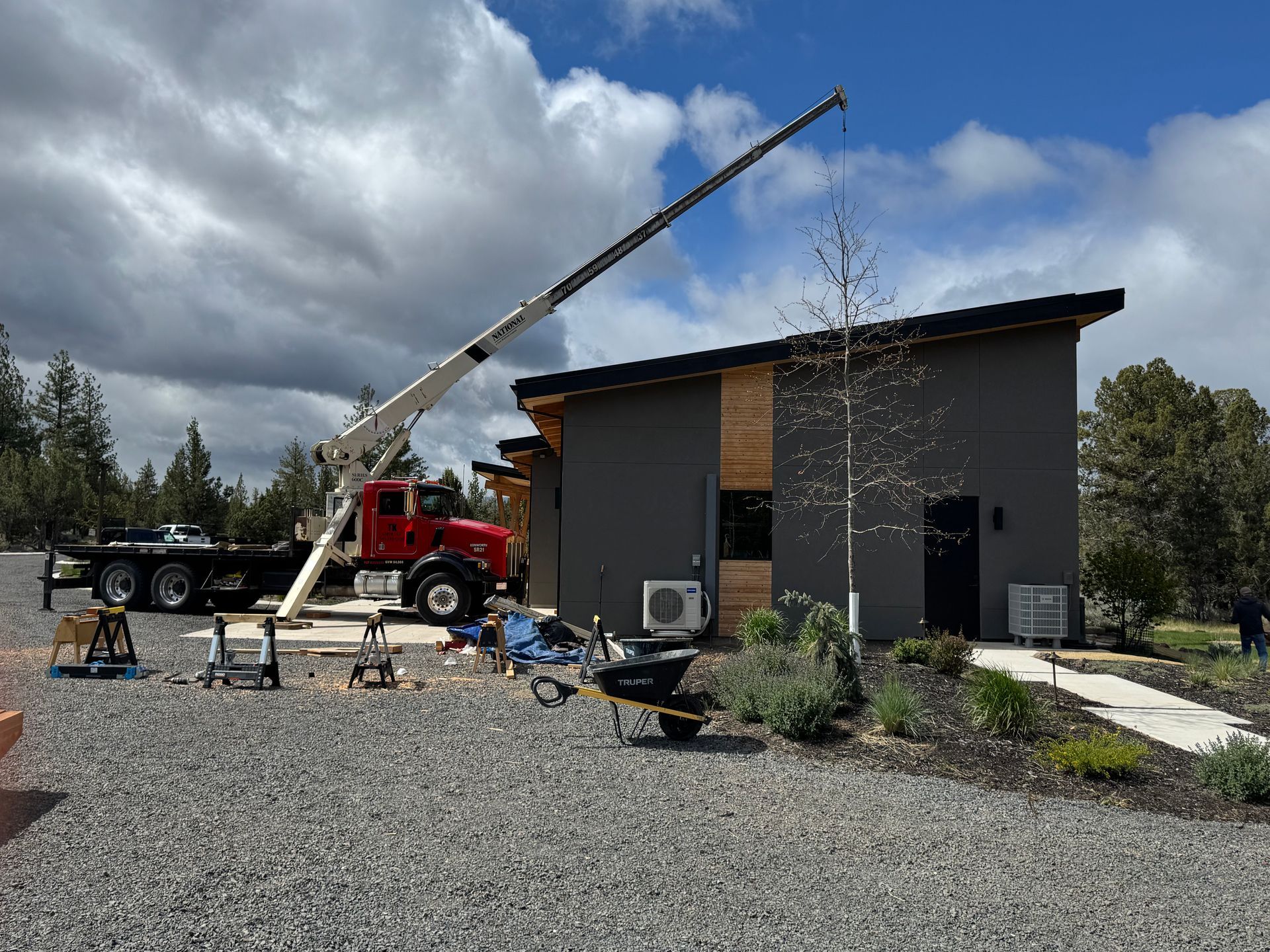 A truck with a crane attached to it is parked in front of a house.